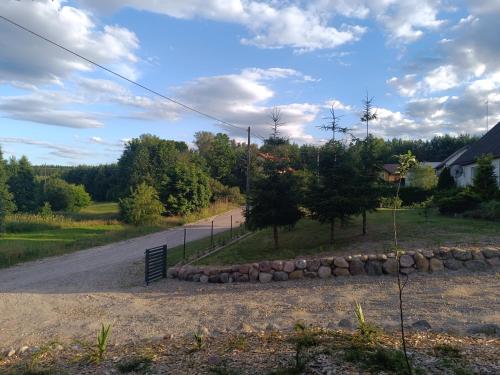 a road with a fence and a rock wall at Agroturystyka Pod Pstrągiem in Lipnica