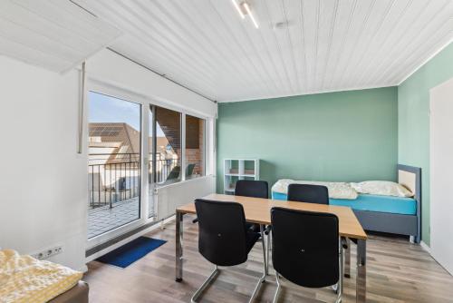 una stanza con un tavolo, sedie e un letto di Sali Homes - Monteurswohnungen im Herzen von Kleve a Kleve