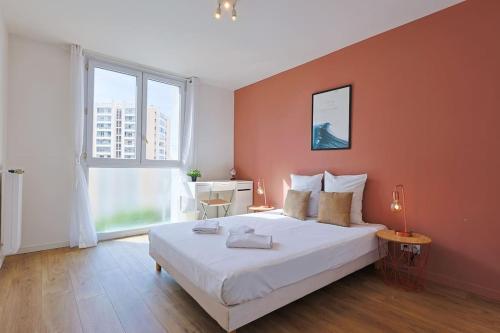 une chambre avec un grand lit avec un mur orange dans l'établissement Saint Mathieu 5 minutes du port et gare wifi 10minutes plage, à Toulon