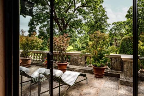 a balcony with chairs and potted plants on a fence at Cowley Manor Experimental in Cheltenham