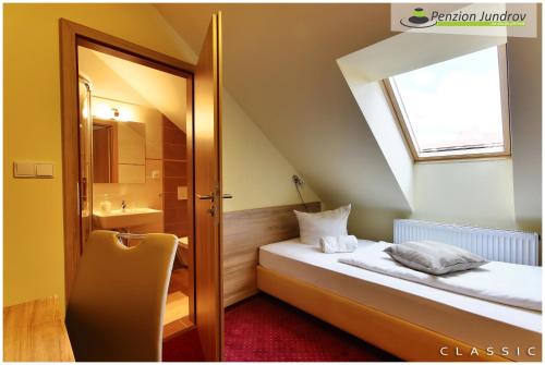 a small room with a bed and a bathroom at Penzion Vanessa in Brno