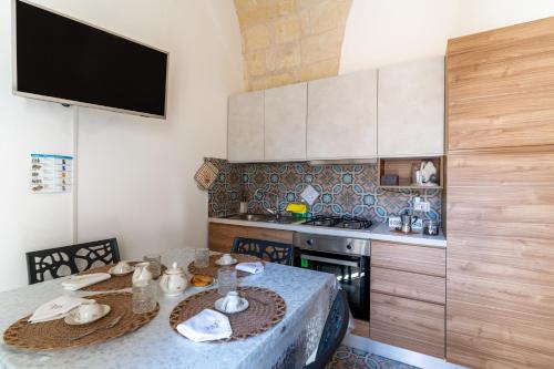 a small kitchen with a table and a stove at La casa di nonna Pina in Giurdignano
