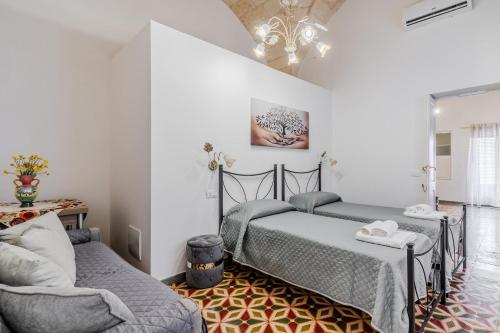 a bedroom with two beds and a couch at La casa di nonna Pina in Giurdignano