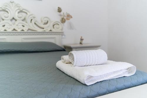 a pile of towels sitting on top of a bed at La casa di nonna Pina in Giurdignano
