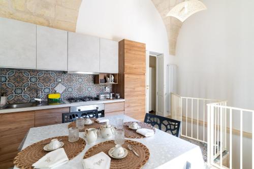 a kitchen with a table with a white table cloth at La casa di nonna Pina in Giurdignano