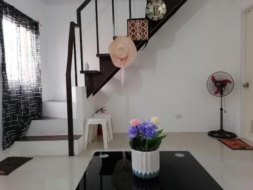 a room with a table with a vase with flowers on it at G&M Comfy Place for your stay in Pagadian in Pagadian