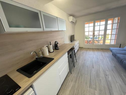 une cuisine avec un évier et un salon dans l'établissement AGAY plage, à Saint-Raphaël