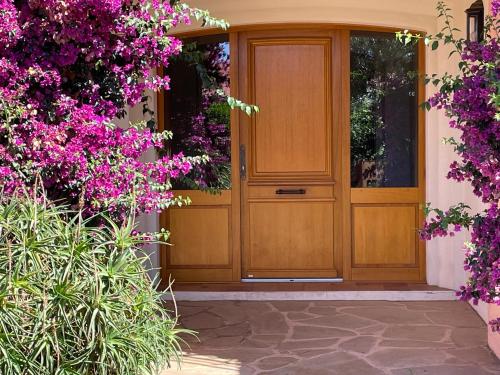 une porte en bois sur une maison avec des fleurs violettes dans l'établissement AGAY plage, à Saint-Raphaël
