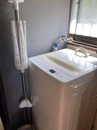a bathroom with a washing machine and a sink at 一棟貸切温泉旅館house kuu in Kirishima