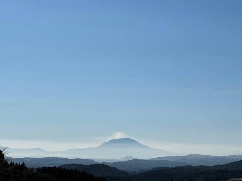 a view of a mountain in the distance at 一棟貸切温泉旅館house kuu in Kirishima