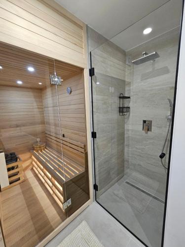 a sauna with a walk in shower and a glass shower stall at Luxury Apartment Ane in Zadar