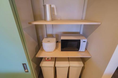 a kitchen with a microwave and a mixer on a shelf at Nostalgia Nasa in Nasa