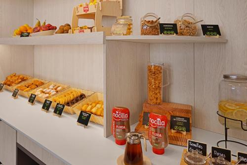 a shelf with various types of bread and other foods at B&B HOTEL Logroño Las Cañas in Viana