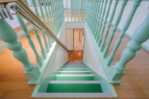 a stairway with green carpet and white stairs at Nostalgia Nasa in Nasa