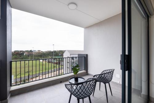 a balcony with two chairs and a table at Ballito Village Luxury Apartments in Ballito