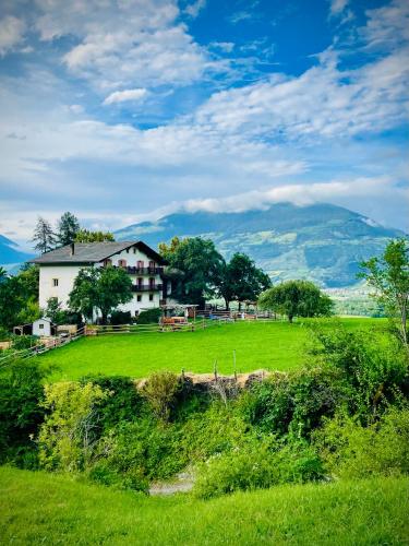 a white house on a green field with mountains in the background at Plasur - Apartement Bella Vista in Montechiaro