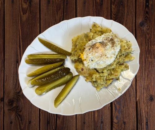 a plate of food with eggs and pickles on a table at Ostrzycka Gościna u Maryli in Ostrzyce
