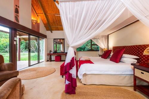 a bedroom with a large bed with a canopy at Leopard Walk Lodge in Hluhluwe