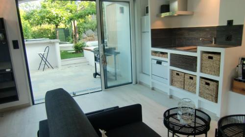 a living room with a couch and a kitchen at Casa Louise - Piscine et jacuzzi privatifs in Sainte-Maxime