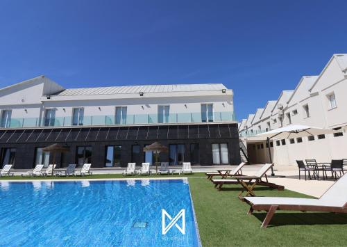 a hotel with a swimming pool in front of a building at Hotel Lena Village in Mortágua