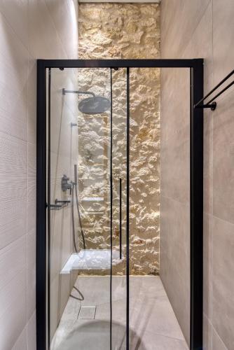 a shower with a glass door in a bathroom at The Alma City Suites in Chania