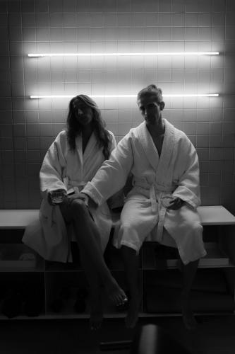 a man and woman sitting on a bench in a bathroom at Neo Suites in Fira
