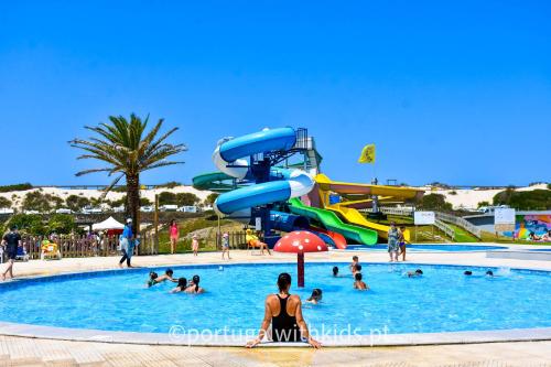 un gruppo di persone in una piscina in un parco acquatico di Villa Rafa a Costa Nova