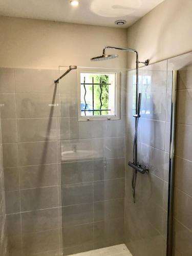 La salle de bains est pourvue d'une douche et d'une fenêtre. dans l'établissement La Bergerie de Chateau Fontvert, à Lourmarin