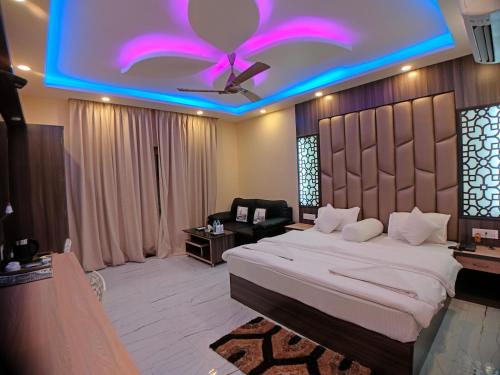 a bedroom with a large bed with a purple ceiling at The Triton Beach Resort in Mandarmoni