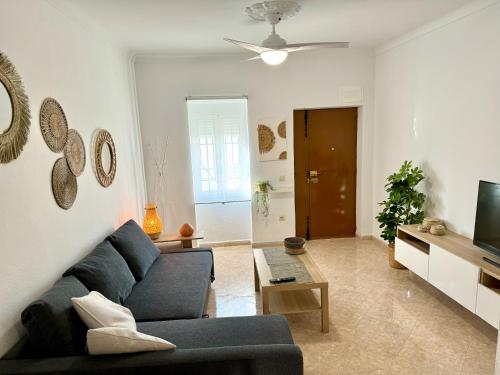 a living room with a blue couch and a tv at Vistas del Valle in Valle de Abdalagís