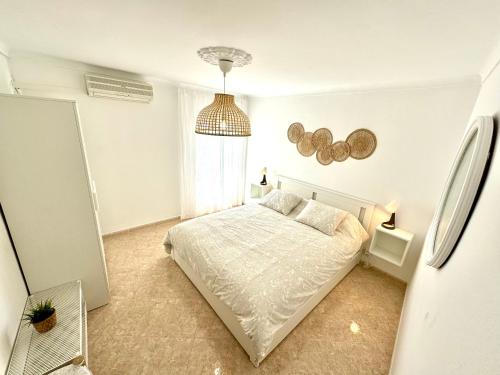 a white bedroom with a bed and a window at Vistas del Valle in Valle de Abdalagís