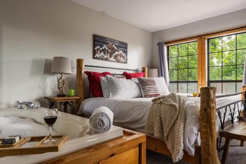 a bedroom with a bed and a tub and windows at Elevista - Quaint&Private-Views-HotTub-PoolTable-Bears-3 Clubhouse Pools in Gatlinburg