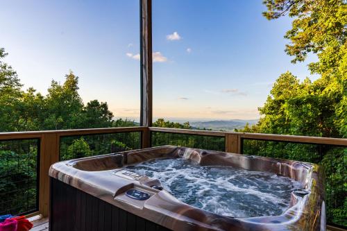 a jacuzzi tub on a balcony with a view at Elevista - Quaint&Private-Views-HotTub-PoolTable-Bears-3 Clubhouse Pools in Gatlinburg