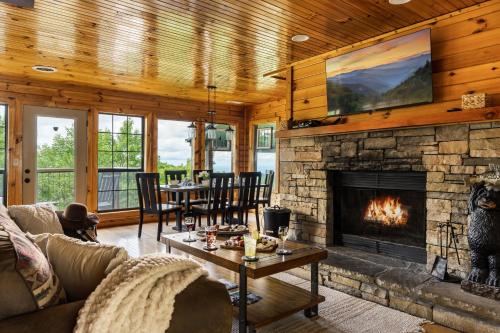 a living room with a stone fireplace and a table at Elevista - Quaint&Private-Views-HotTub-PoolTable-Bears-3 Clubhouse Pools in Gatlinburg