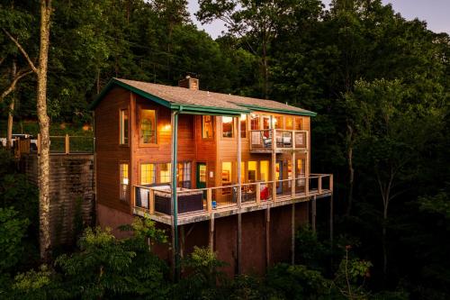 a wooden house with a large deck in the woods at Elevista - Quaint&Private-Views-HotTub-PoolTable-Bears-3 Clubhouse Pools in Gatlinburg
