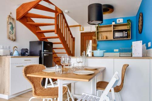 une cuisine avec une table et des chaises ainsi qu'un escalier dans l'établissement À 3km de la plage, maison pour 4, à Fouesnant