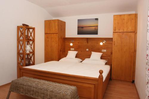 Schlafzimmer mit einem großen Bett mit einem Kopfteil aus Holz in der Unterkunft Ferienwohnung am Römerweg Wald in Inzell