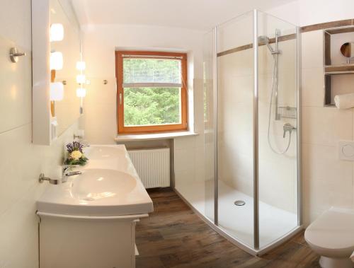 ein Bad mit einem Waschbecken und einer Dusche in der Unterkunft Ferienwohnung am Römerweg Wald in Inzell