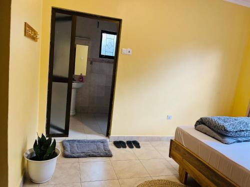 a bathroom with a bed and a shower with a mirror at Kaanyi homestay in Arusha