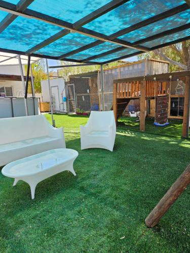 two white couches sitting under a canopy in a yard at חצבים על הואדי in Arad
