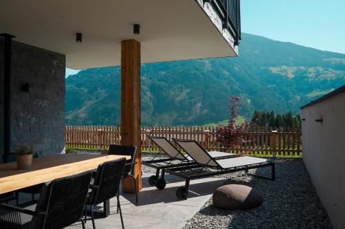 a patio with chairs and a table and a view at Chalet WildRuh in Ried im Zillertal
