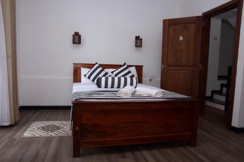 a bed with black and white pillows on it at Peaceful Peak in Kandy