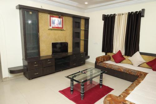 a living room with a couch and a television at Laxminarayan service apartment in Shirdi