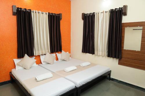 a room with a large bed with white pillows at Laxminarayan service apartment in Shirdi