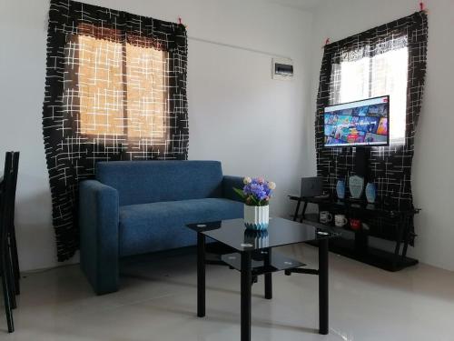 a living room with a blue couch and a table at G&M Comfy Place for your stay in Pagadian in Pagadian