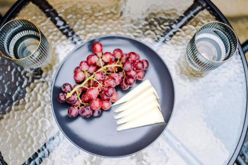a plate of cheese and grapes on a table at Modern Premium 3 Bed Hidden Gem - Central Location in Barnsley