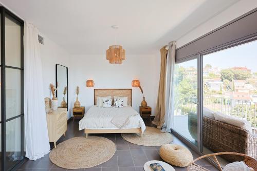 a bedroom with a bed and a large window at Villa Aya Barca in Santa Susanna