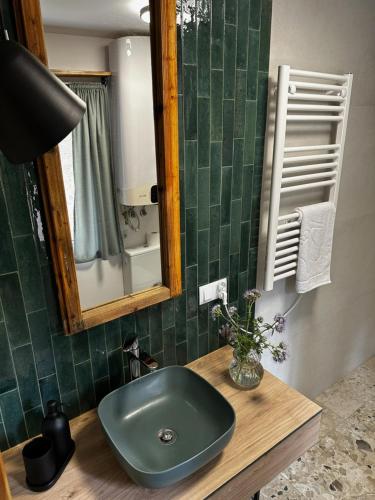 a bathroom with a green sink and a mirror at Domki Sosnówka in Majdan Sopocki