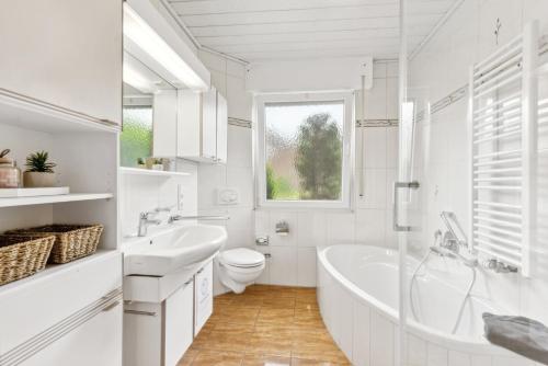 a white bathroom with a tub and a toilet at Alter Ziegelhof, Terrasse, WLAN, bis zu 11 Personen in Vechta