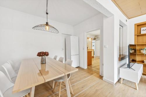 a dining room with a wooden table and white chairs at Alter Ziegelhof, Terrasse, WLAN, bis zu 11 Personen in Vechta